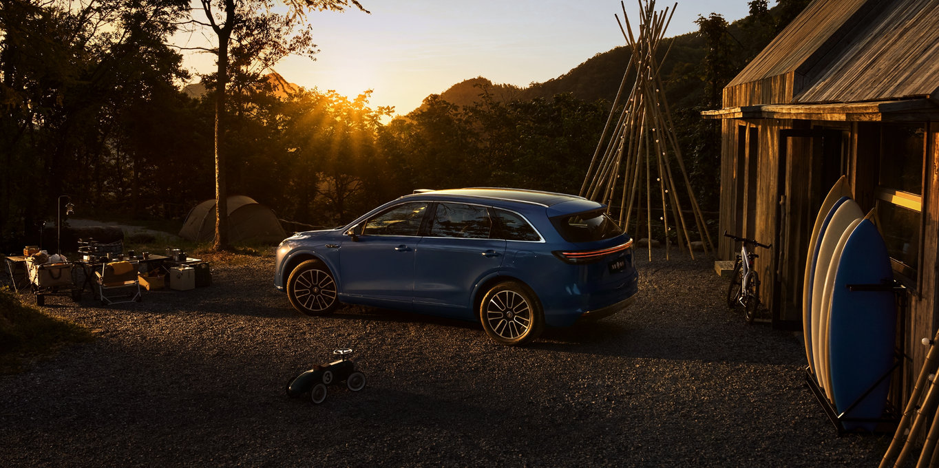 两名儿童在车外嬉戏，周边有许多气球