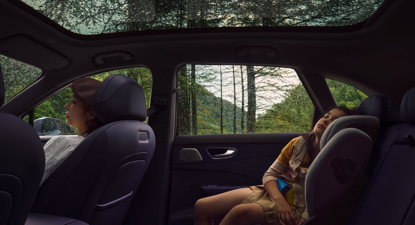 一名儿童坐在尚界 H5 内休息