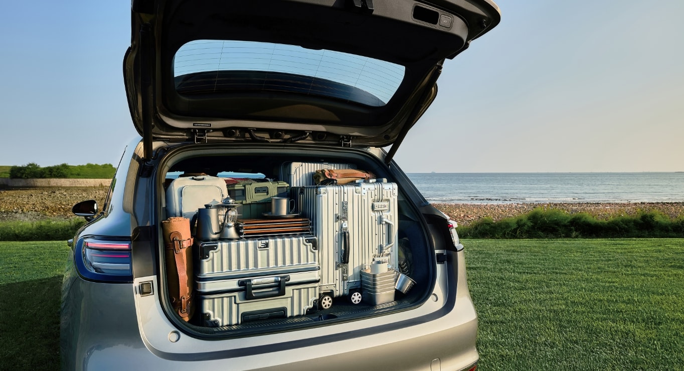 一名儿童坐在尚界 H5 后备箱暗格中，旁边还装着玩具