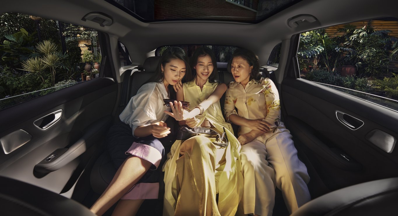 三名女性一起坐在尚界 H5 后排，展示了宽敞的后排真“三人座”