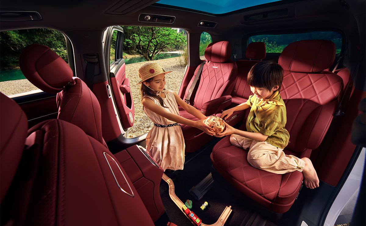 两个小孩子坐在问界 M8 星云红的二排座椅上