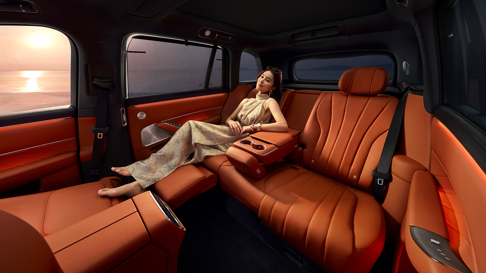 一个女人躺在问界 M8 赤茶橘展开的的二排零重力座椅上