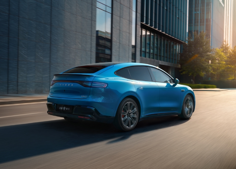 智界 R7 行驶在草地，展示了其动态转向辅助功能