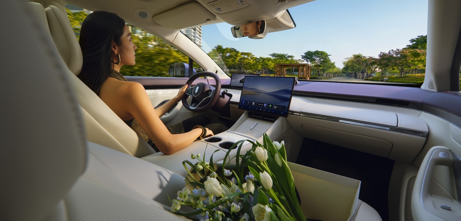 一位女士驾驶智界 R7，状态松弛，展示了汽车三温区空调带来舒适的车内环境