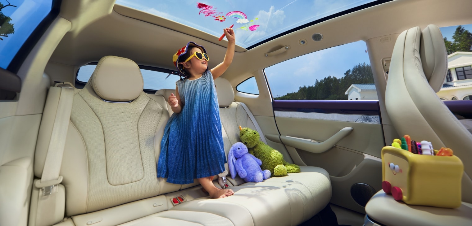 一个小女孩光脚站在后排座椅，往天窗上涂鸦，展示了智界 R7 丝云座椅带来的舒适触感